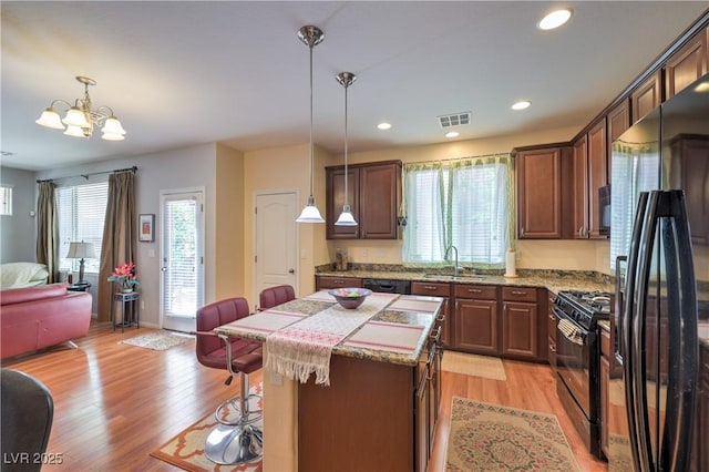 10353 Yew Blossom Ave, Las Vegas, NV 89166 - kitchen with black appliances, open floor plan, a sink, a chandelier, and a breakfast bar area