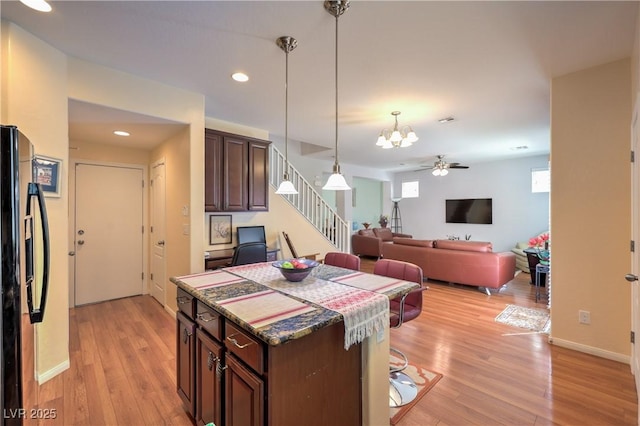 10353 Yew Blossom Ave, Las Vegas, NV 89166 - kitchen with freestanding refrigerator, a chandelier, a center island, pendant lighting, and light wood-type flooring