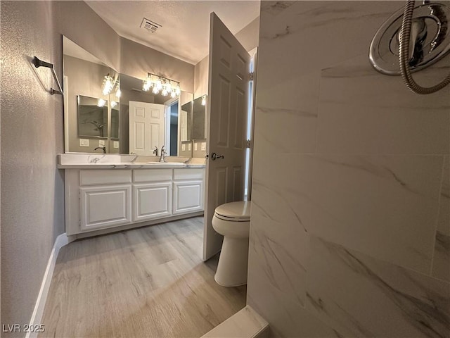 3340 Shallow Pond Dr, Las Vegas, NV 89117 - bathroom with wood finished floors, double vanity, toilet, baseboards, and a textured wall