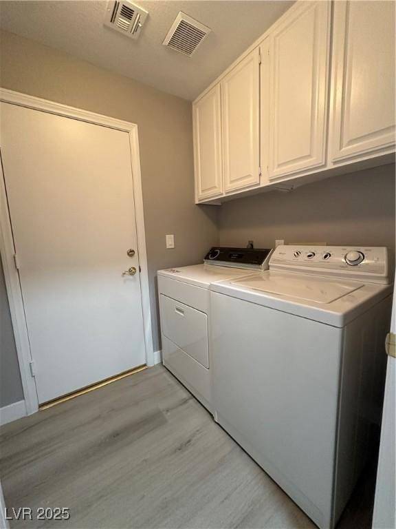 3340 Shallow Pond Dr, Las Vegas, NV 89117 - laundry room with washer and clothes dryer, light wood finished floors, cabinet space, and baseboards