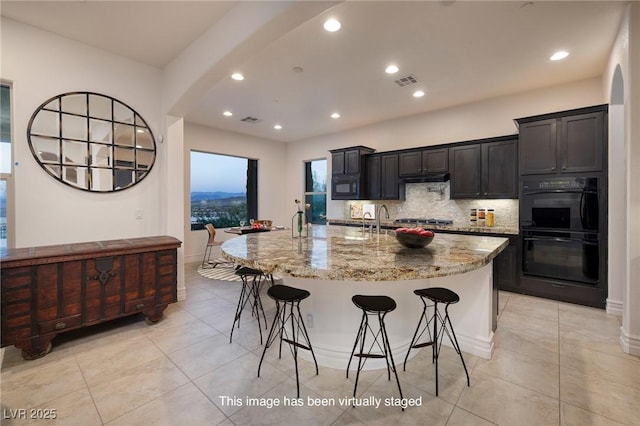 8 Laricola Ct, Henderson, NV 89011 - kitchen with black appliances, light tile patterned floors, arched walkways, a kitchen bar, and recessed lighting
