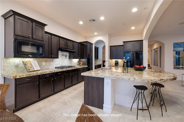 8 Laricola Ct, Henderson, NV 89011 - kitchen with arched walkways, black appliances, a sink, backsplash, and light tile patterned floors
