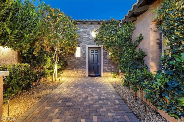 8 Laricola Ct, Henderson, NV 89011 - entrance to property with stucco siding, stone siding, and a tiled roof
