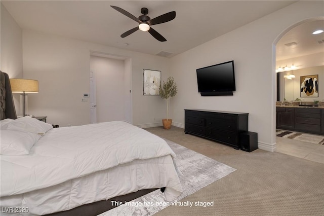 8 Laricola Ct, Henderson, NV 89011 - bedroom with light carpet, arched walkways, connected bathroom, baseboards, and a ceiling fan