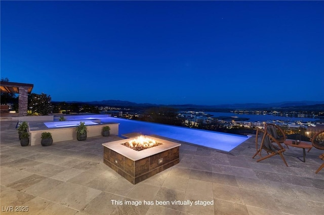 8 Laricola Ct, Henderson, NV 89011 - pool at night with an outdoor fire pit and a patio area