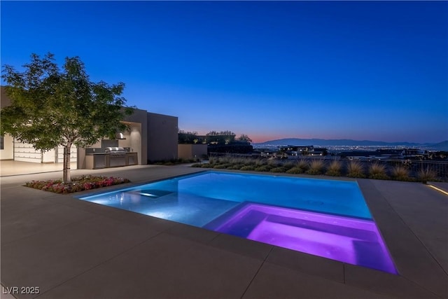 6 Rockmount Ct, Henderson, NV 89012 - pool at dusk featuring an outdoor kitchen, a patio, and a pool with connected hot tub
