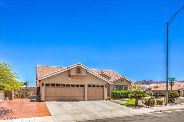 1044 Spanish Needle St, Henderson, NV 89002 - mediterranean / spanish-style house featuring stucco siding, a tile roof, an attached garage, and concrete driveway