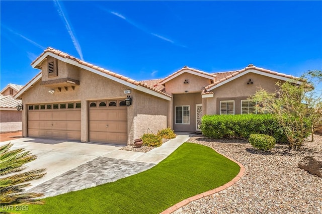 1044 Spanish Needle St, Henderson, NV 89002 - mediterranean / spanish-style home with stucco siding, concrete driveway, a tiled roof, and an attached garage