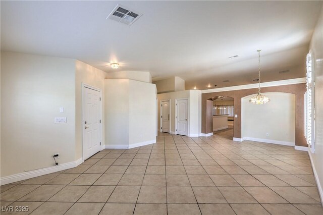 1044 Spanish Needle St, Henderson, NV 89002 - unfurnished living room featuring arched walkways, light tile patterned flooring, a chandelier, and baseboards