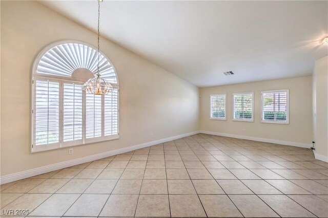 1044 Spanish Needle St, Henderson, NV 89002 - empty room featuring a chandelier, vaulted ceiling, light tile patterned floors, and baseboards