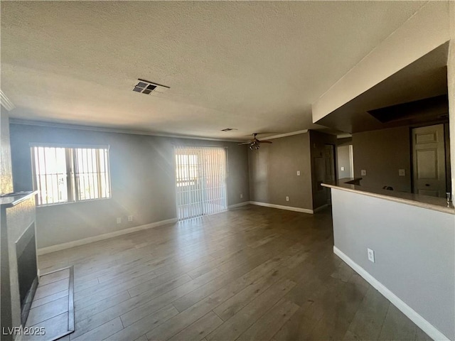 8600 W Charleston Blvd Unit 2033, Las Vegas, NV 89117 - unfurnished living room with crown molding, a ceiling fan, baseboards, dark wood-style floors, and a textured ceiling