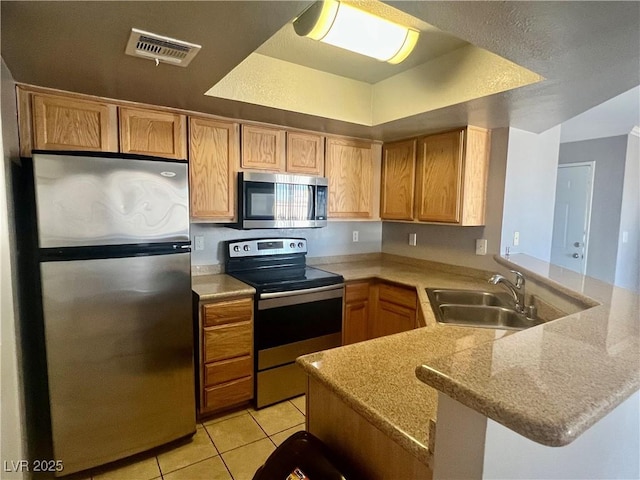 8600 W Charleston Blvd Unit 2033, Las Vegas, NV 89117 - kitchen with appliances with stainless steel finishes, a sink, a peninsula, light tile patterned floors, and light countertops