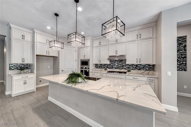 101 Mirage View Dr, Henderson, NV 89011 - kitchen featuring a chandelier, gas stovetop, under cabinet range hood, backsplash, and white cabinets