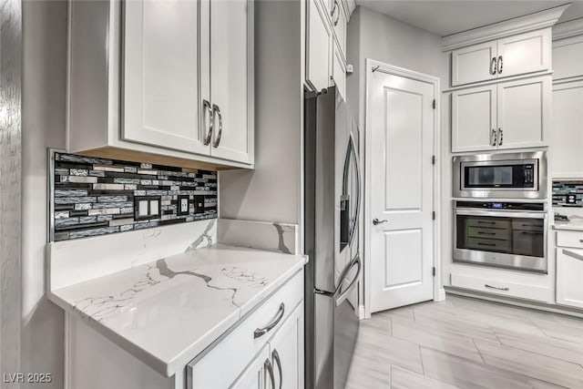 101 Mirage View Dr, Henderson, NV 89011 - kitchen featuring appliances with stainless steel finishes, light stone countertops, backsplash, and white cabinetry