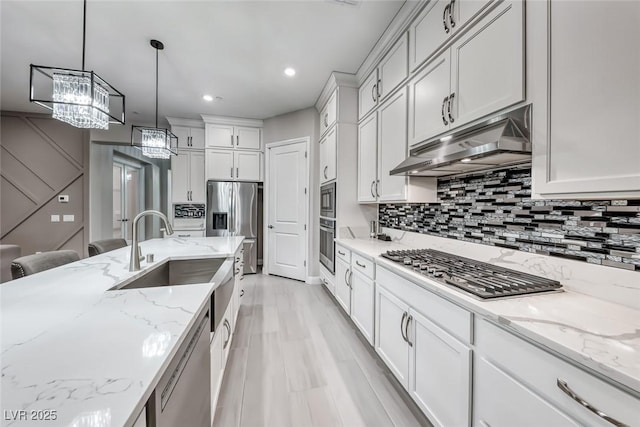 101 Mirage View Dr, Henderson, NV 89011 - kitchen with under cabinet range hood, stainless steel appliances, a sink, backsplash, and recessed lighting