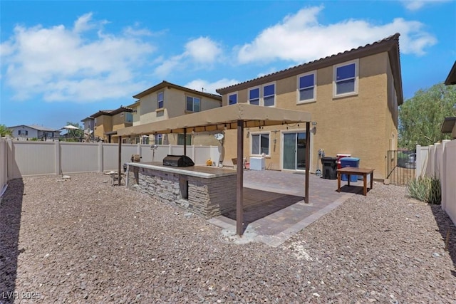 2117 Leatherbridge Ct, North Las Vegas, NV 89081 - back of house featuring exterior kitchen, a fenced backyard, stucco siding, a patio area, and a residential view
