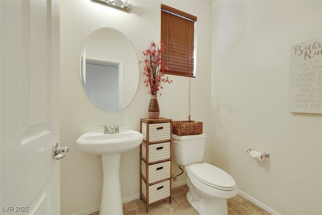 2117 Leatherbridge Ct, North Las Vegas, NV 89081 - half bathroom featuring toilet, baseboards, a sink, and tile patterned flooring