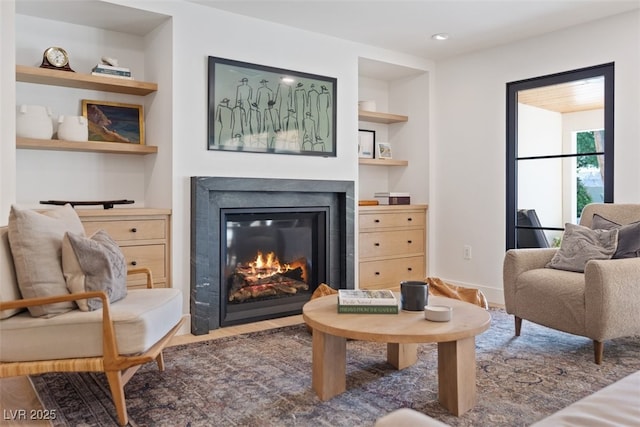 204 Canyon Dr, Las Vegas, NV 89107 - living area featuring built in shelves, a fireplace with flush hearth, wood finished floors, and baseboards
