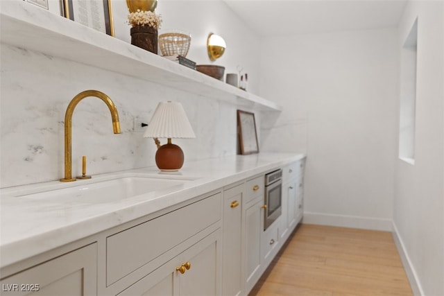 204 Canyon Dr, Las Vegas, NV 89107 - kitchen featuring a sink, light wood finished floors, baseboards, light countertops, and wall oven