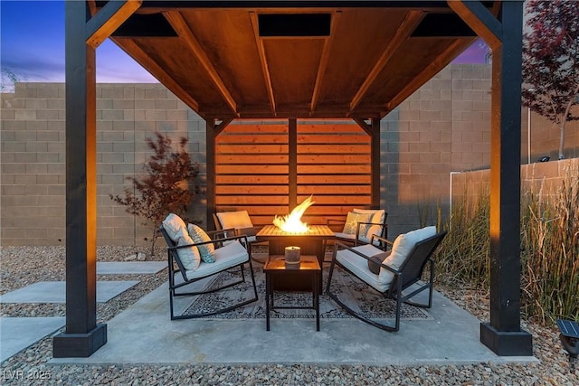 2367 Ridgeline Wash St, Las Vegas, NV 89138 - patio terrace at dusk featuring an outdoor fire pit, a patio area, and a fenced backyard