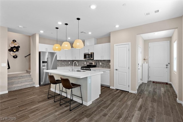 2367 Ridgeline Wash St, Las Vegas, NV 89138 - kitchen with stainless steel appliances, a sink, dark wood-style floors, an island with sink, and recessed lighting