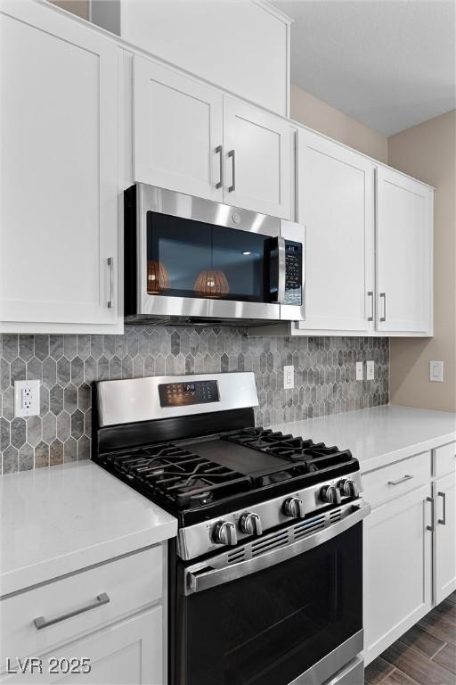 2367 Ridgeline Wash St, Las Vegas, NV 89138 - kitchen with stainless steel appliances, light countertops, white cabinets, and backsplash
