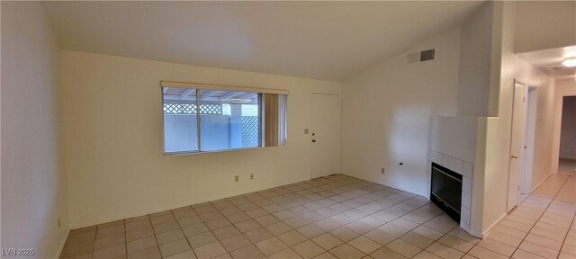 2216 Short Pine Dr, Las Vegas, NV 89108 - unfurnished living room with light tile patterned floors, lofted ceiling, and a glass covered fireplace