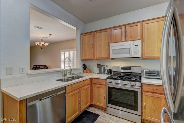 2304 Willow Wren Dr, North Las Vegas, NV 89084 - kitchen featuring appliances with stainless steel finishes, a sink, light countertops, and a chandelier