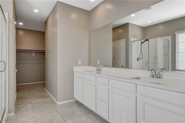 8486 Insignia Ave Unit 101, Las Vegas, NV 89178 - bathroom featuring a shower stall, a spacious closet, double vanity, baseboards, and recessed lighting