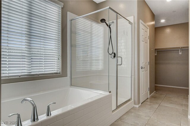 8486 Insignia Ave Unit 101, Las Vegas, NV 89178 - bathroom with a shower stall, a bath, tile patterned floors, a spacious closet, and baseboards