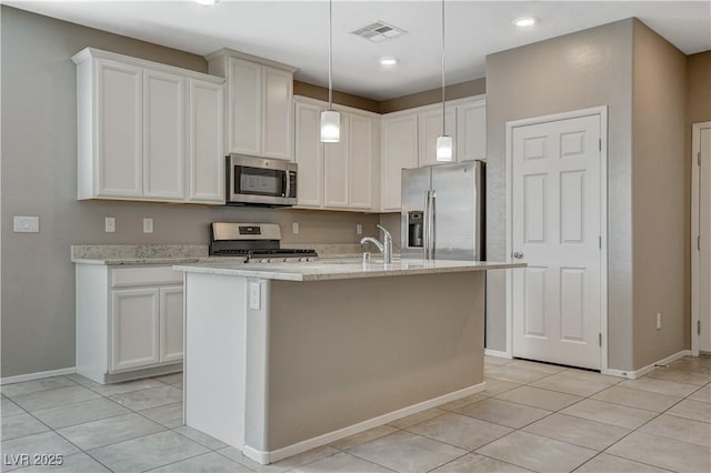 8486 Insignia Ave Unit 101, Las Vegas, NV 89178 - kitchen featuring appliances with stainless steel finishes, light tile patterned floors, baseboards, white cabinetry, and a kitchen island with sink