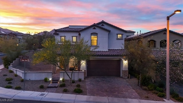 11856 Barona Mesa Ave, Las Vegas, NV 89138 - mediterranean / spanish home featuring a tiled roof, stucco siding, decorative driveway, and a garage