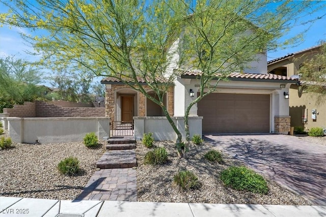 11856 Barona Mesa Ave, Las Vegas, NV 89138 - mediterranean / spanish house featuring stone siding, stucco siding, a tiled roof, a fenced front yard, and a garage