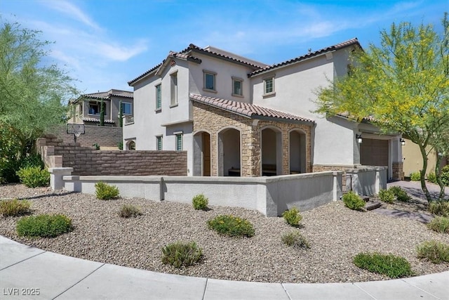 11856 Barona Mesa Ave, Las Vegas, NV 89138 - mediterranean / spanish house featuring a fenced front yard, stucco siding, a tiled roof, and stone siding