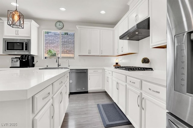 11856 Barona Mesa Ave, Las Vegas, NV 89138 - kitchen with stainless steel appliances, under cabinet range hood, light countertops, recessed lighting, and white cabinets