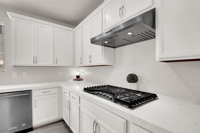 11856 Barona Mesa Ave, Las Vegas, NV 89138 - kitchen featuring appliances with stainless steel finishes, under cabinet range hood, white cabinetry, light countertops, and wood finished floors
