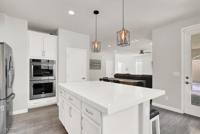 11856 Barona Mesa Ave, Las Vegas, NV 89138 - kitchen with stainless steel appliances, white cabinetry, wood finished floors, and recessed lighting