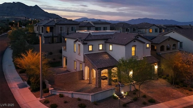 11856 Barona Mesa Ave, Las Vegas, NV 89138 - view of front of home featuring a tiled roof, a mountain view, stucco siding, a residential view, and decorative driveway