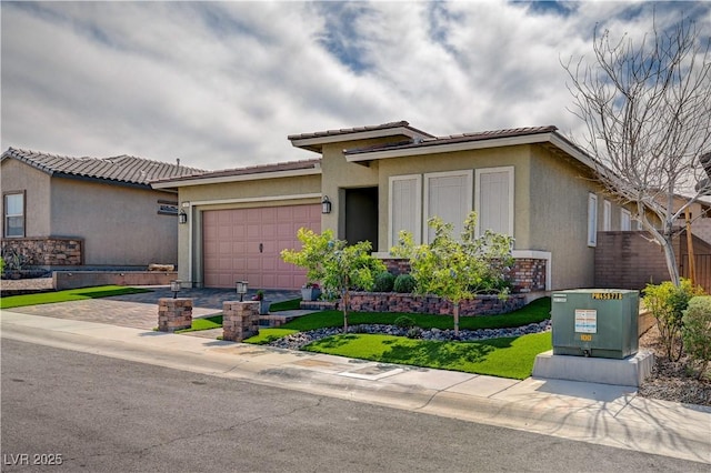 505 Sterling Falls Ave, Henderson, NV 89011 - view of front facade featuring stucco siding, decorative driveway, a garage, and a tile roof
