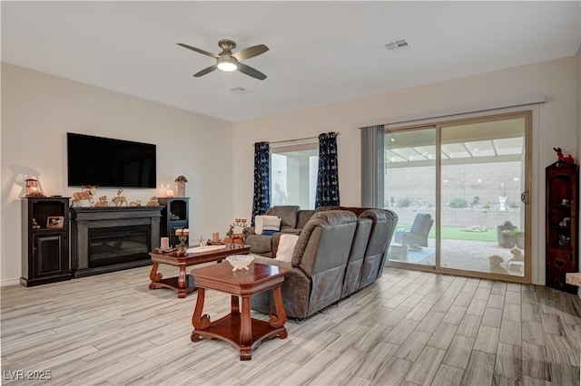505 Sterling Falls Ave, Henderson, NV 89011 - living area featuring light wood-style flooring, a ceiling fan, and a glass covered fireplace