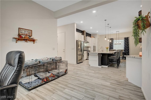 505 Sterling Falls Ave, Henderson, NV 89011 - kitchen featuring stainless steel appliances, a sink, a kitchen breakfast bar, light countertops, and white cabinetry