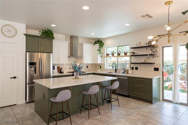 2021 Pelican Sky Beach Ave, North Las Vegas, NV 89081 - kitchen with wall chimney exhaust hood, appliances with stainless steel finishes, a sink, a breakfast bar, and decorative backsplash