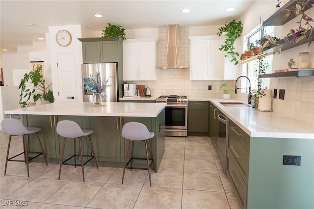 2021 Pelican Sky Beach Ave, North Las Vegas, NV 89081 - kitchen with stainless steel appliances, wall chimney range hood, a sink, a kitchen island, and backsplash