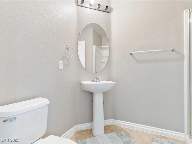 3040 Balcones Fault Ave, North Las Vegas, NV 89081 - bathroom with tile patterned floors, toilet, baseboards, and a shower
