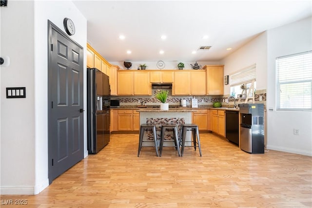 11134 Casala Ct, Las Vegas, NV 89141 - kitchen with black appliances, light brown cabinetry, a center island, under cabinet range hood, and backsplash