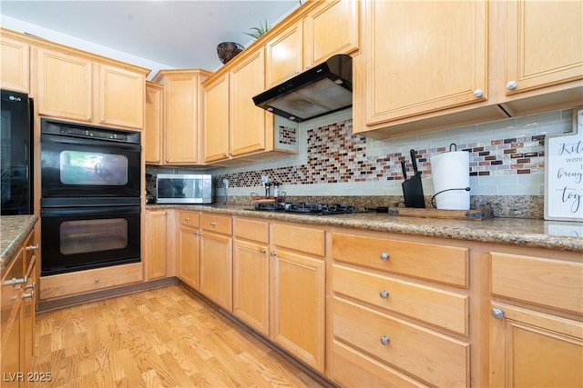 11134 Casala Ct, Las Vegas, NV 89141 - kitchen with black appliances, under cabinet range hood, light brown cabinets, light wood-style floors, and decorative backsplash