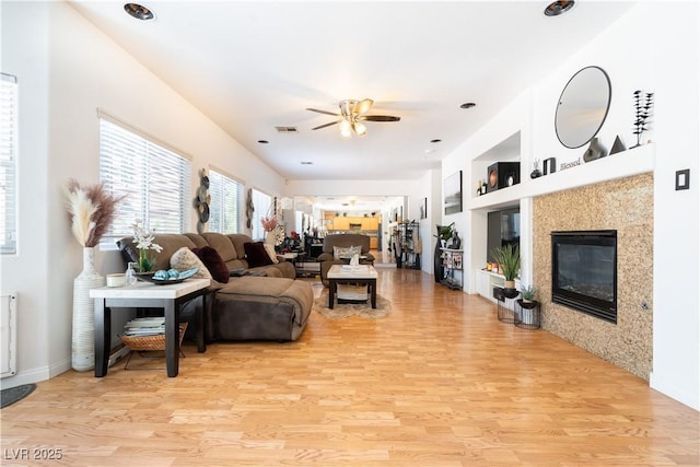 11134 Casala Ct, Las Vegas, NV 89141 - living area featuring a ceiling fan, light wood finished floors, a high end fireplace, and baseboards