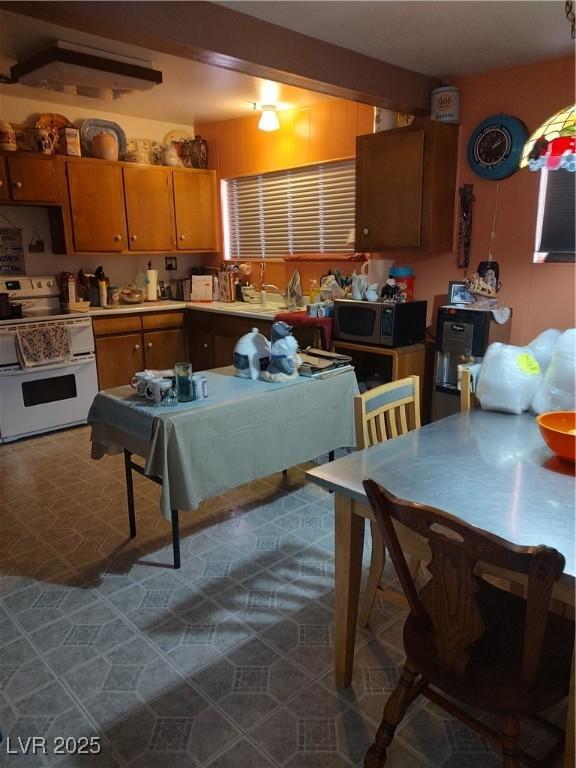 4727 Conrad St, Las Vegas, NV 89121 - kitchen with double oven range, stainless steel microwave, brown cabinetry, and light countertops
