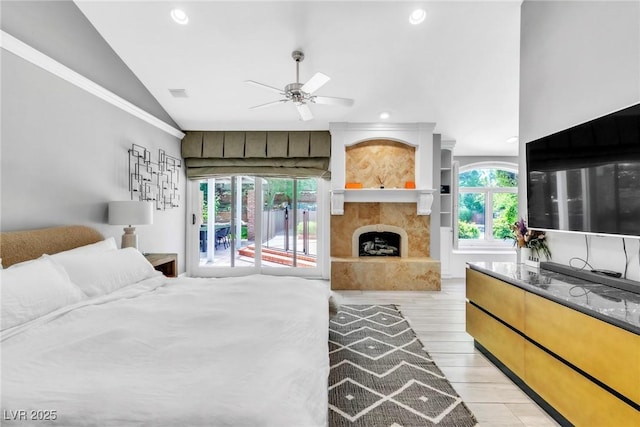 108 Quail Run Rd, Henderson, NV 89014 - bedroom with access to outside, vaulted ceiling, a fireplace with raised hearth, recessed lighting, and light wood-type flooring