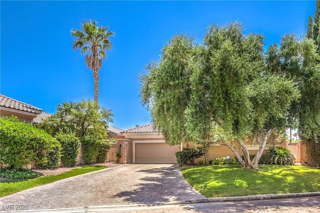27 Via Paradiso St, Henderson, NV 89011 - view of property hidden behind natural elements featuring an attached garage, driveway, stucco siding, and a tile roof